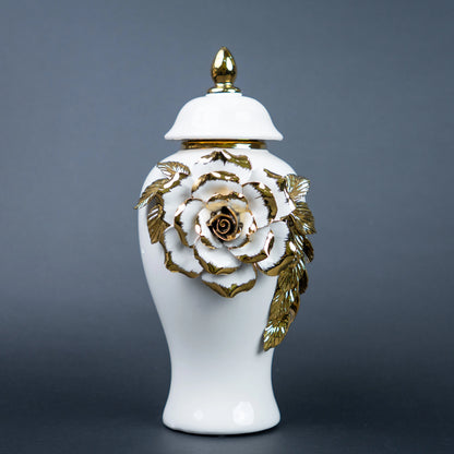 White ceramic jar with gold leaf design and lid on a
