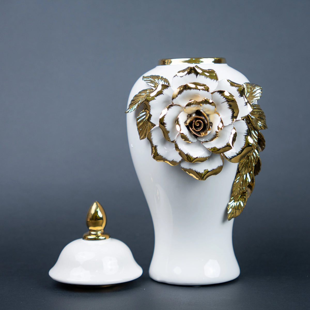 White ceramic jar with gold leaf design and lid on a