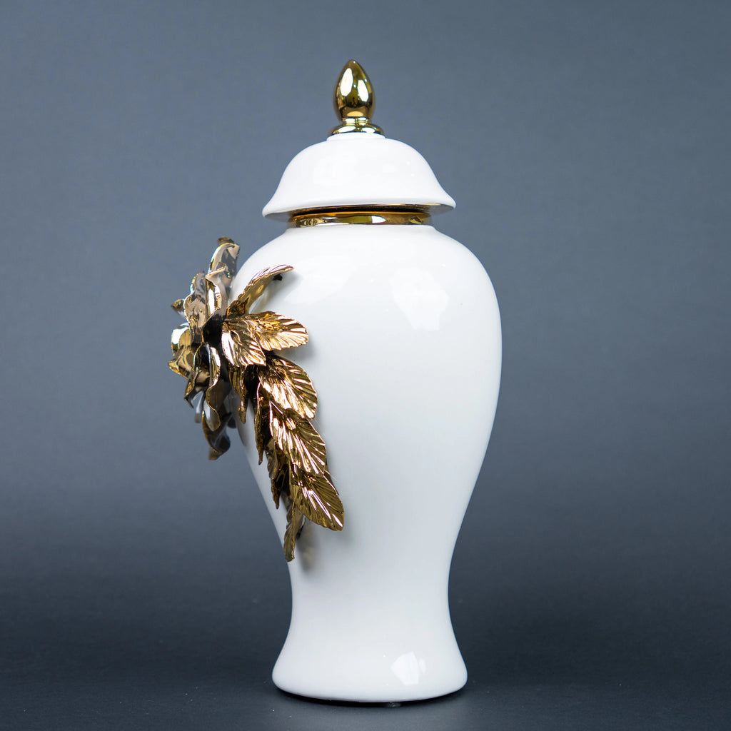 White ceramic jar with gold leaf design and lid on a
