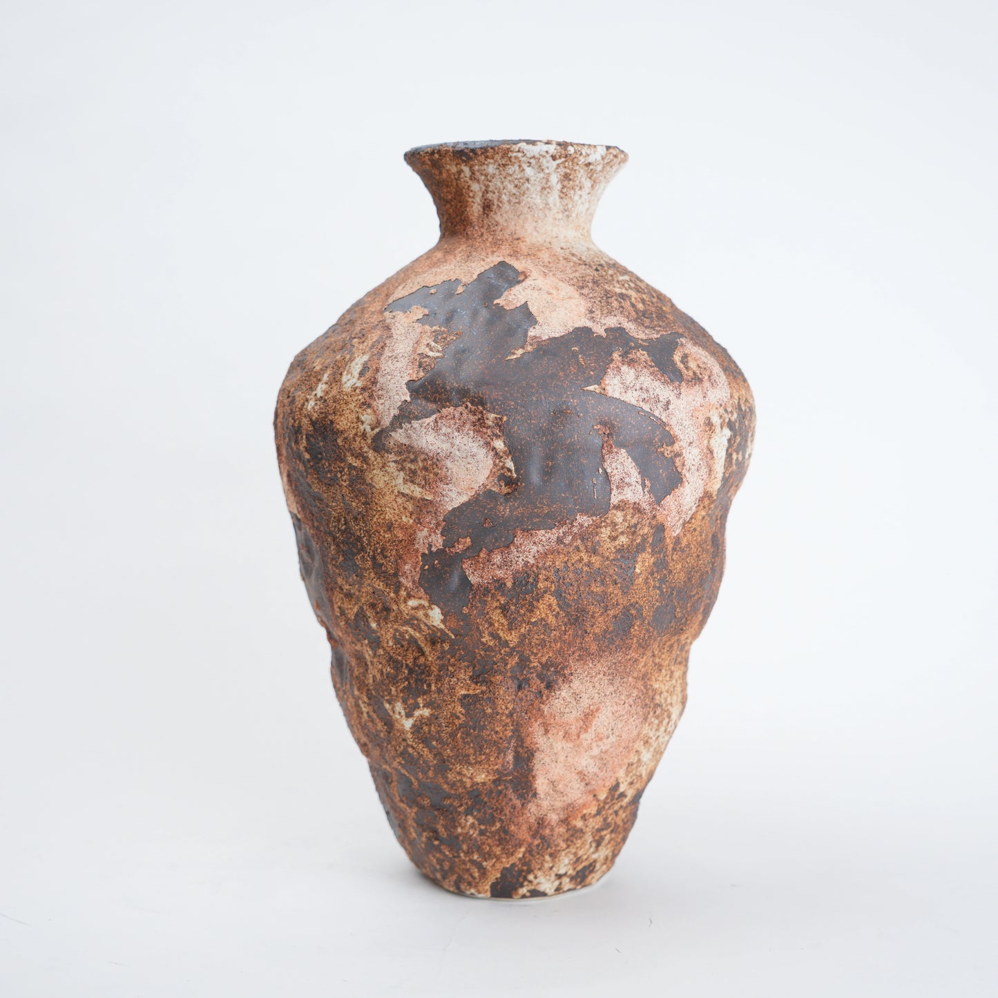 Brown ceramic vase with textured surface on a white background