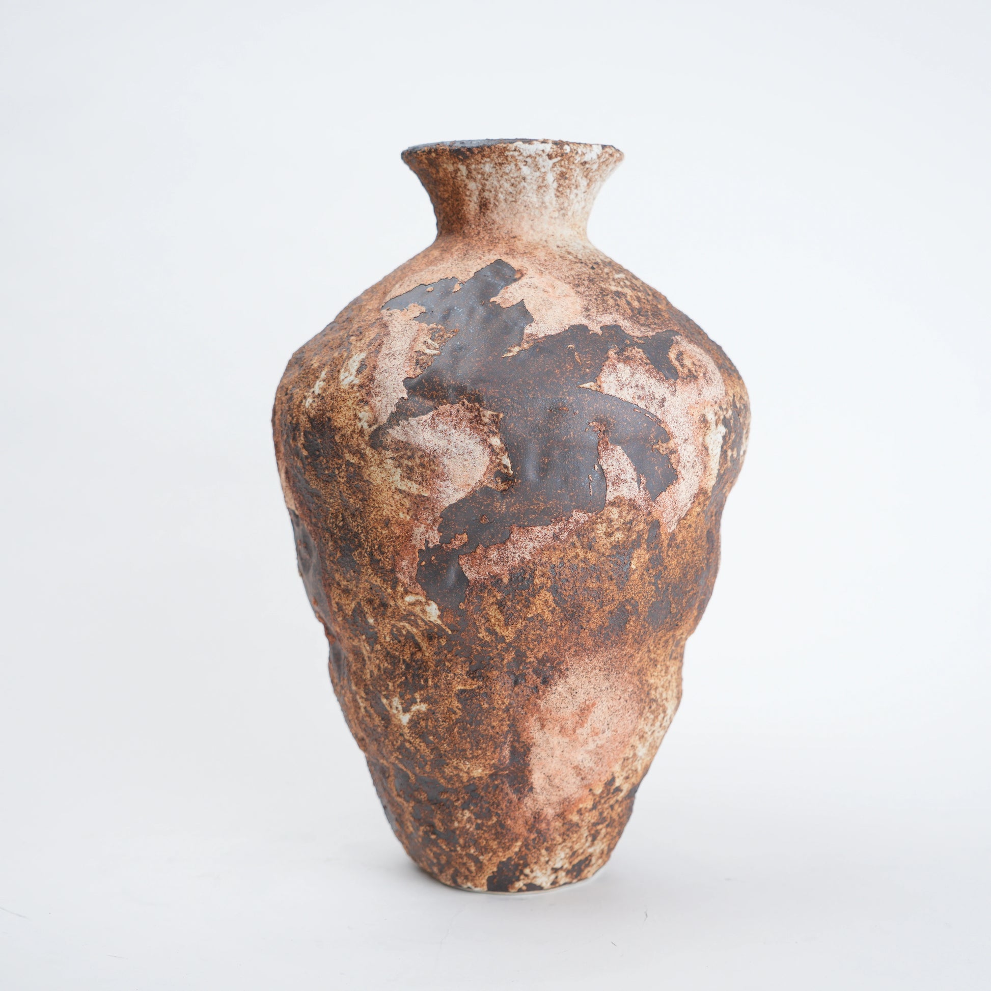 Brown ceramic vase with textured surface on a white background