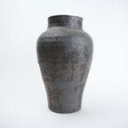 Textured black ceramic vase on a white background