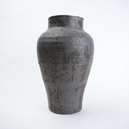 Textured black ceramic vase on a white background