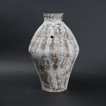 Vintage-style ceramic vase with a textured surface on a dark background