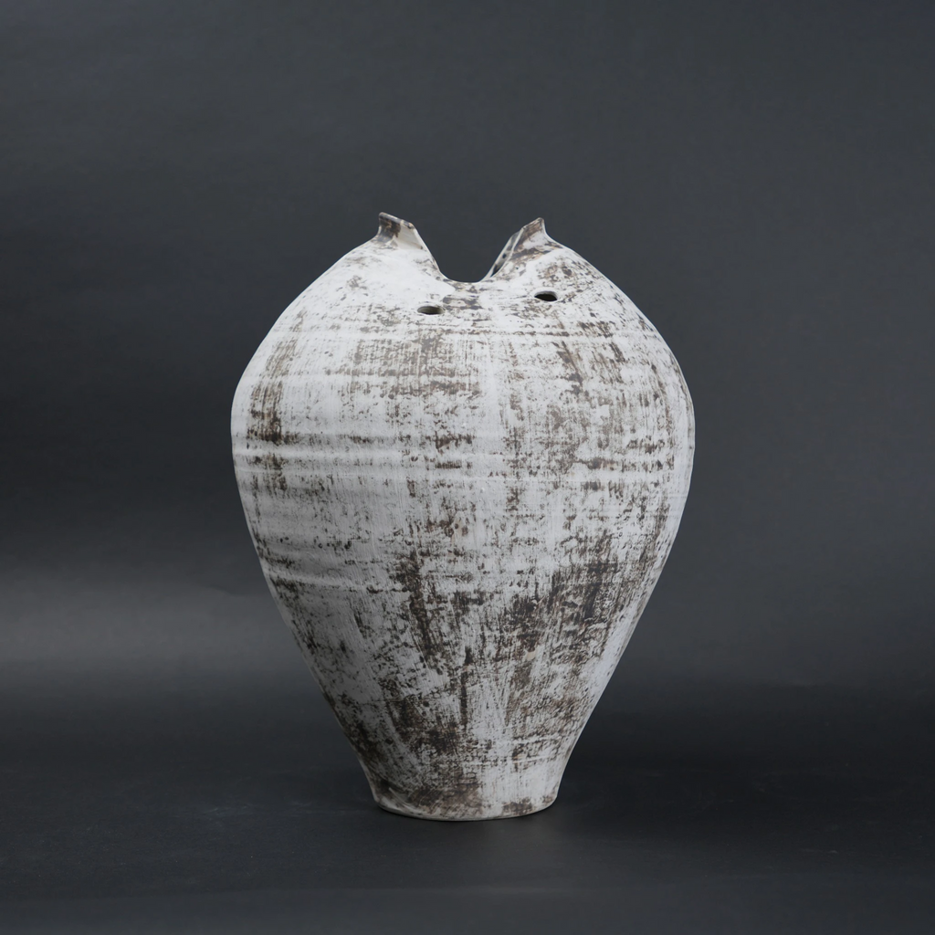 Textured ceramic vase on a dark background