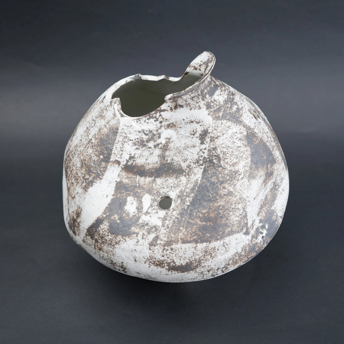 Distressed ceramic vase on a dark background