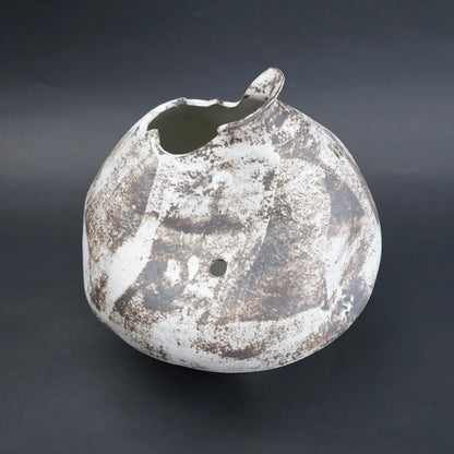 Distressed ceramic vase on a dark background