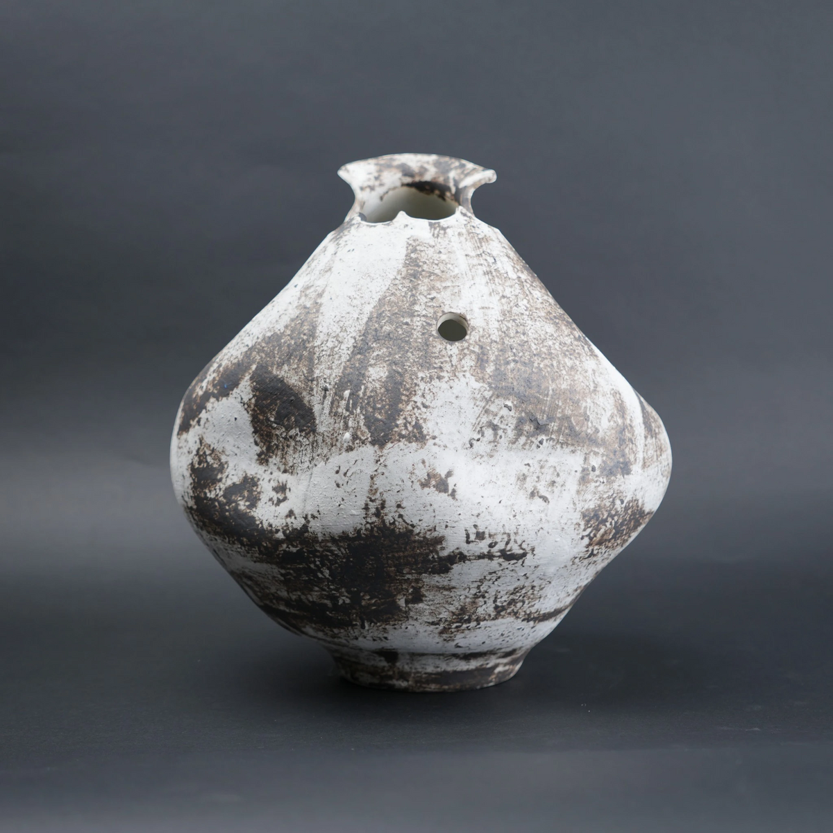 Vintage ceramic vase with a textured surface on a dark background