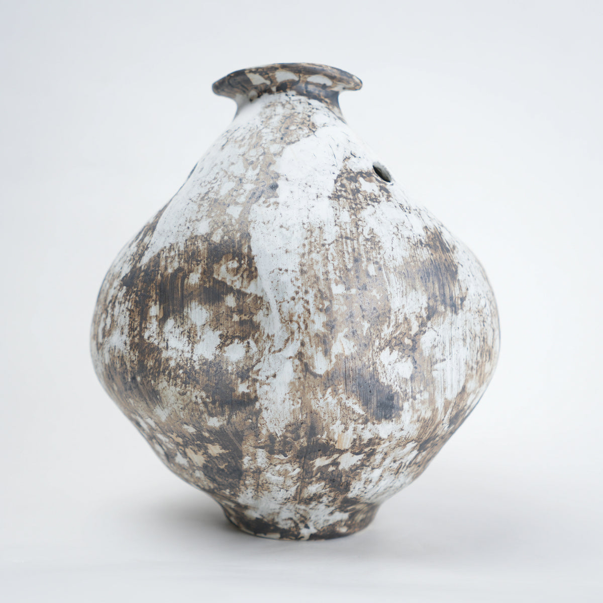 Vintage ceramic vase with a textured surface on a white background
