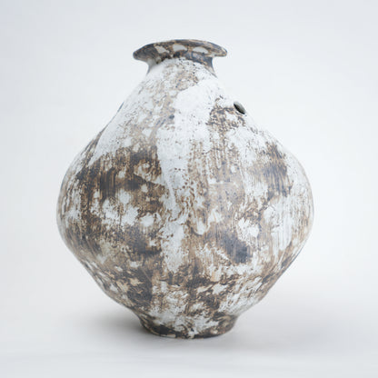 Vintage ceramic vase with a textured surface on a white background