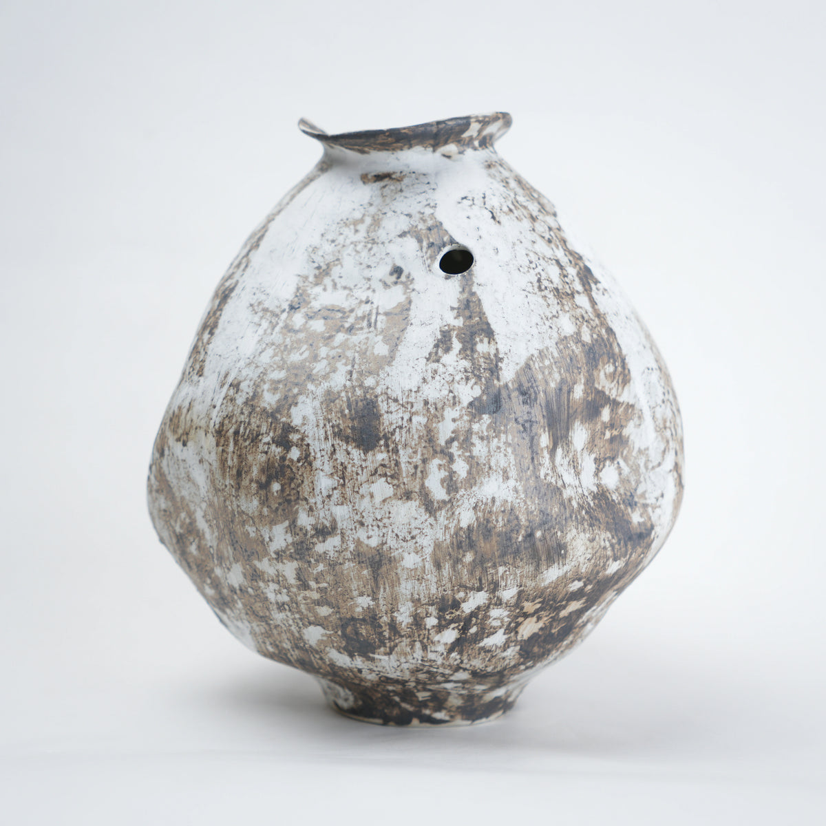 Vintage ceramic vase with a textured surface on a white background
