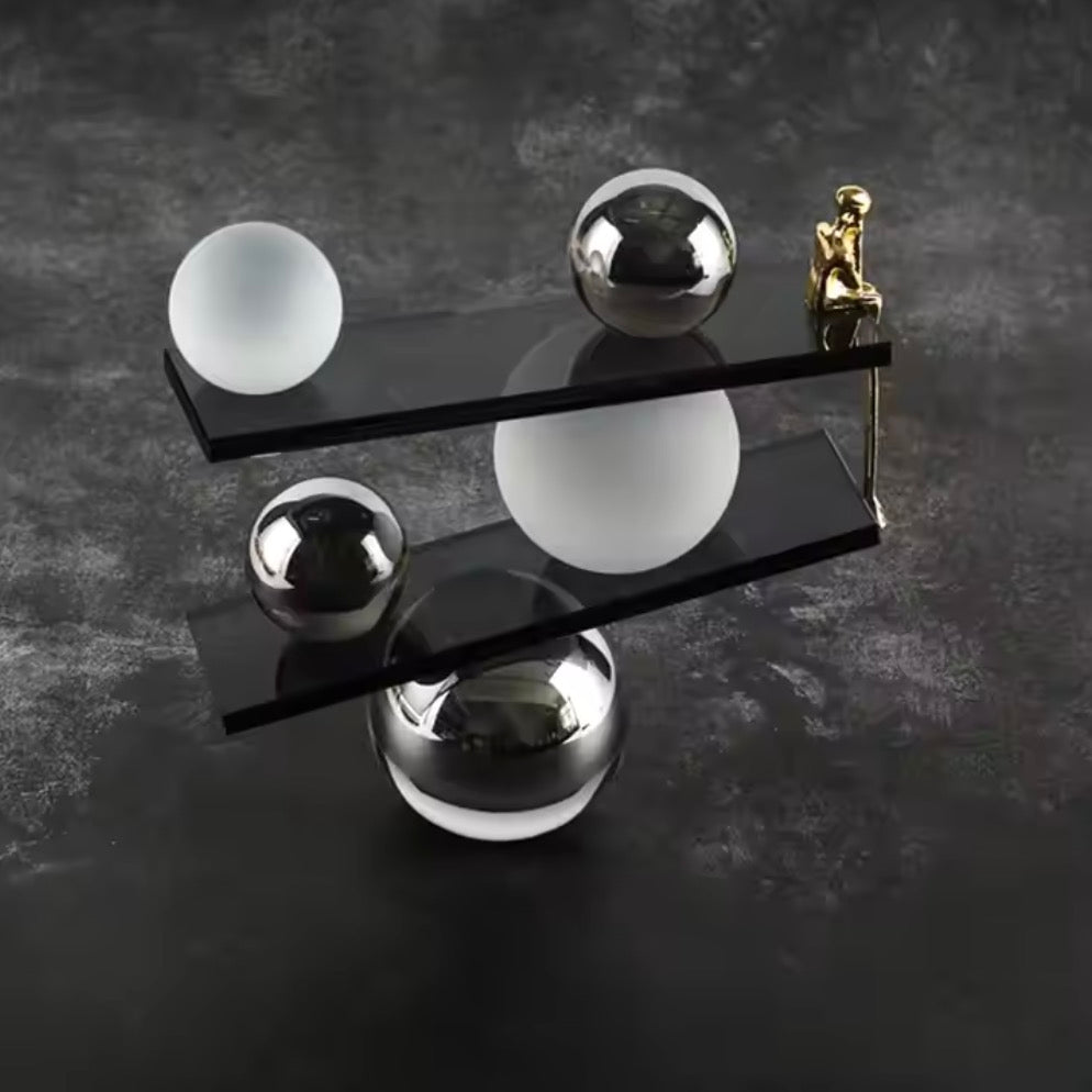 Abstract balancing sculpture with chrome spheres and a small gold figurine