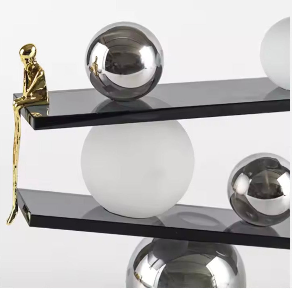 Abstract balancing sculpture with chrome spheres and a small gold figurine