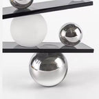 Abstract balancing sculpture with chrome spheres and a small gold figurine