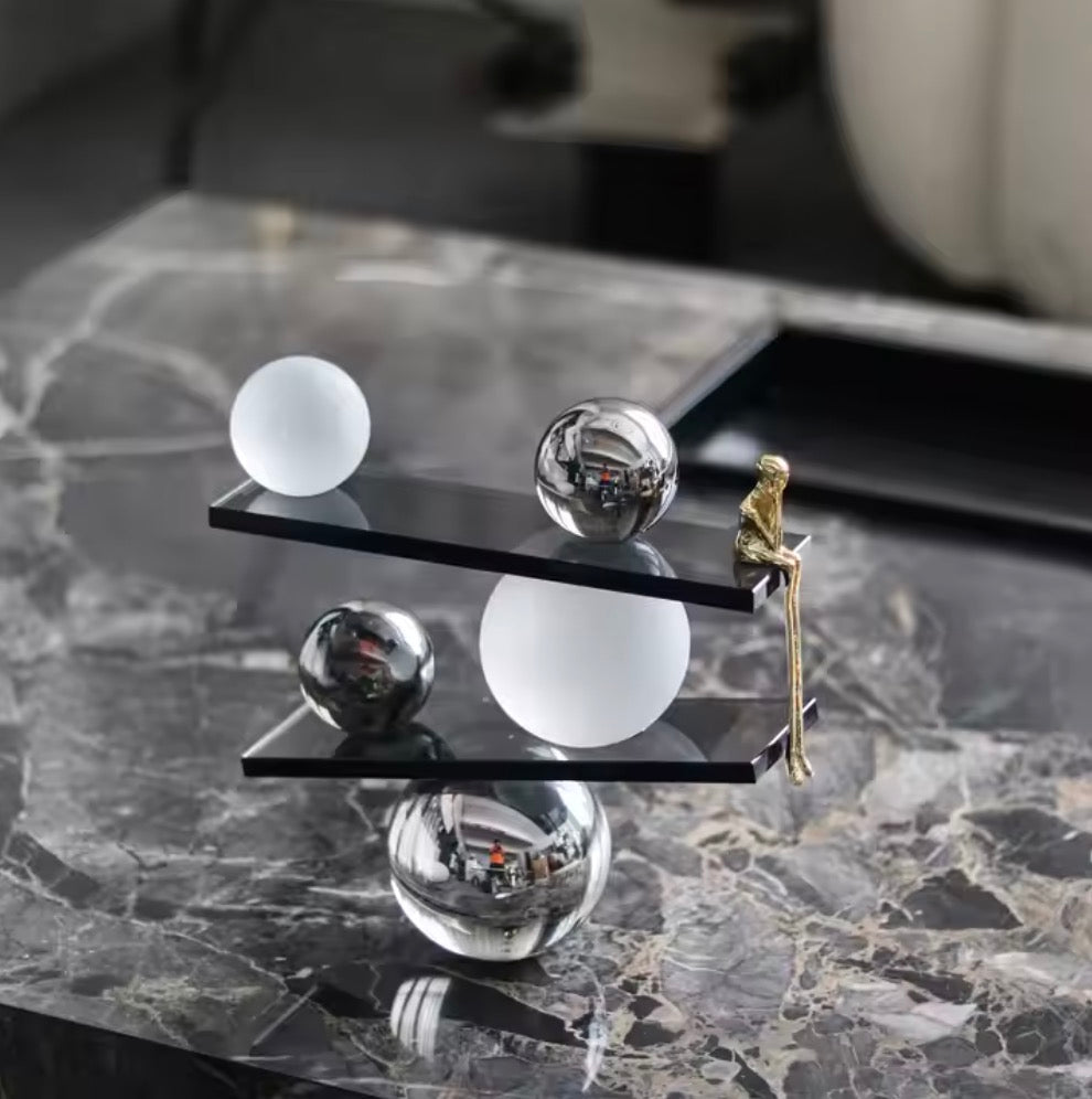 Abstract balancing sculpture with chrome spheres and a small gold figurine