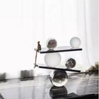 Abstract balancing sculpture with chrome spheres and a small gold figurine