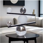 Abstract balancing sculpture with chrome spheres and a small gold figurine