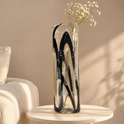Tall clear glass vase with abstract black swirl detailing for modern home décor.