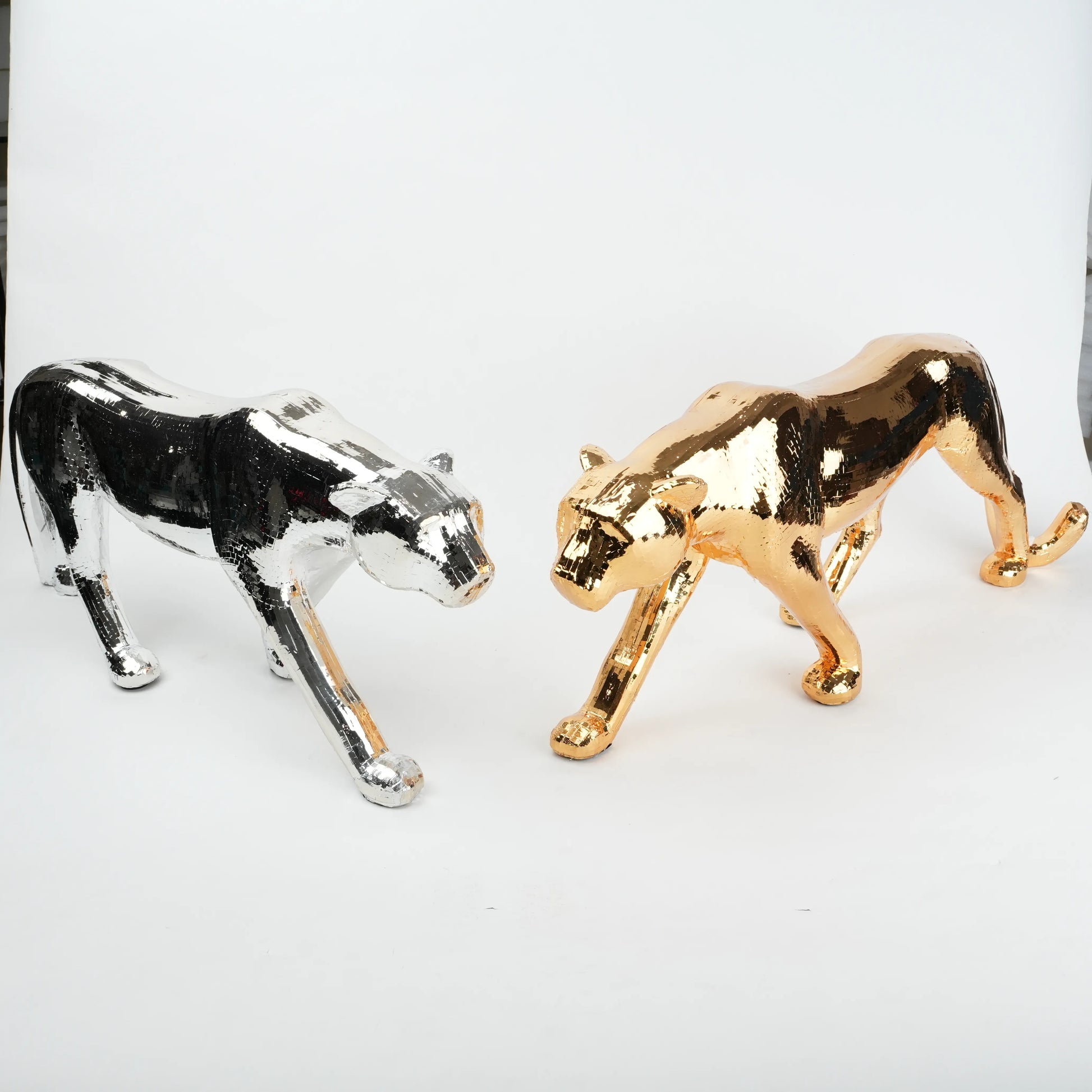 Gold and silver panther figurines on a white background