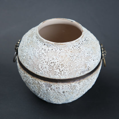 Textured ceramic vase with decorative bands on a dark background