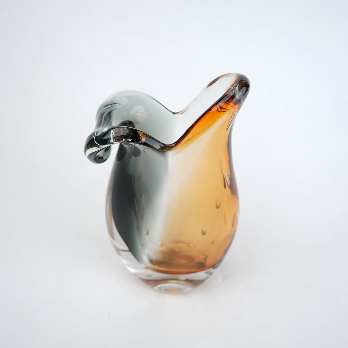Glass object with gradient color from silver to amber on a white background