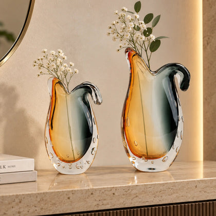 Glass vase with gradient color from gray to orange on a white background