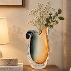 Glass vase with gradient color from gray to orange on a white background