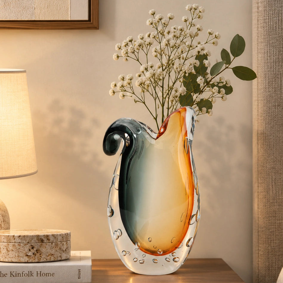 Glass vase with gradient color from gray to orange on a white background