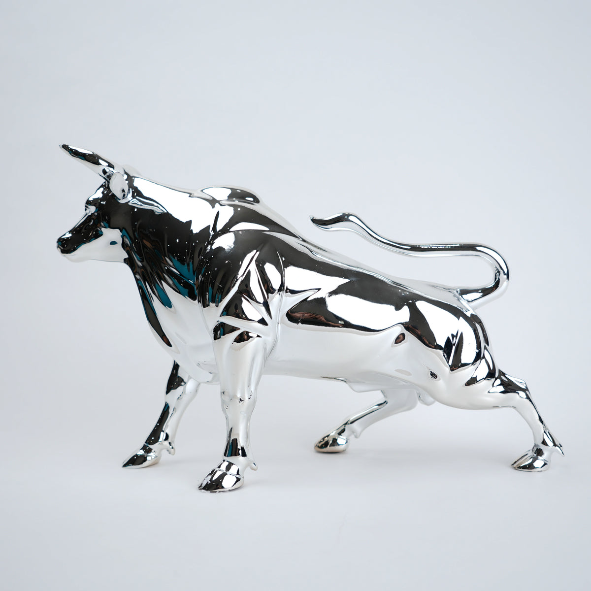 Silver bull sculpture on a light gray background