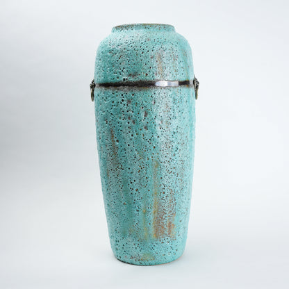Turquoise ceramic urn with decorative patterns on a white background