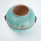 Turquoise ceramic pot with gold speckles on a white background