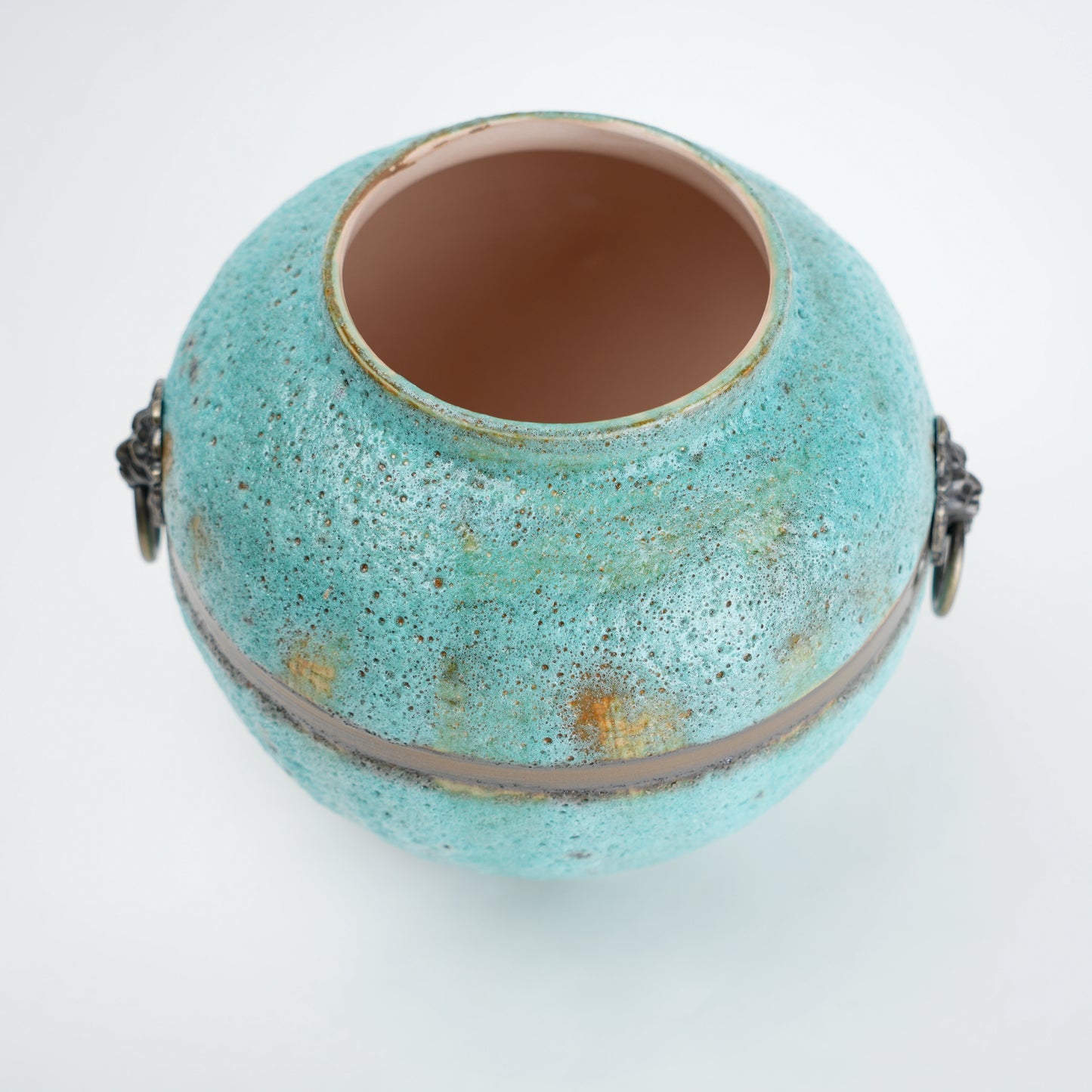 Turquoise ceramic pot with gold speckles on a white background