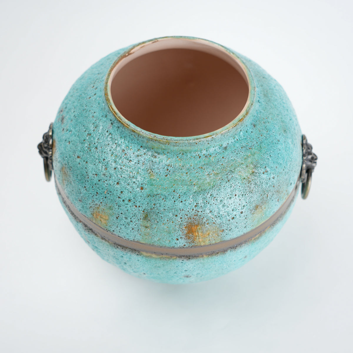 Turquoise ceramic pot with gold speckles on a white background