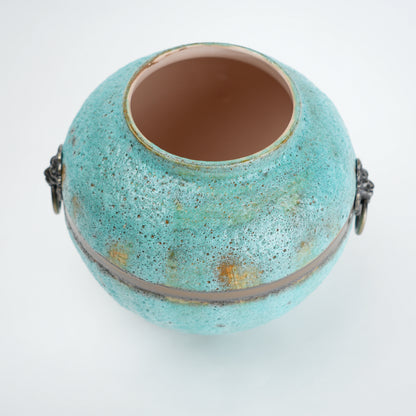 Turquoise ceramic pot with gold speckles on a white background