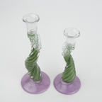 Two glass candle holders with green spiral designs on a white background