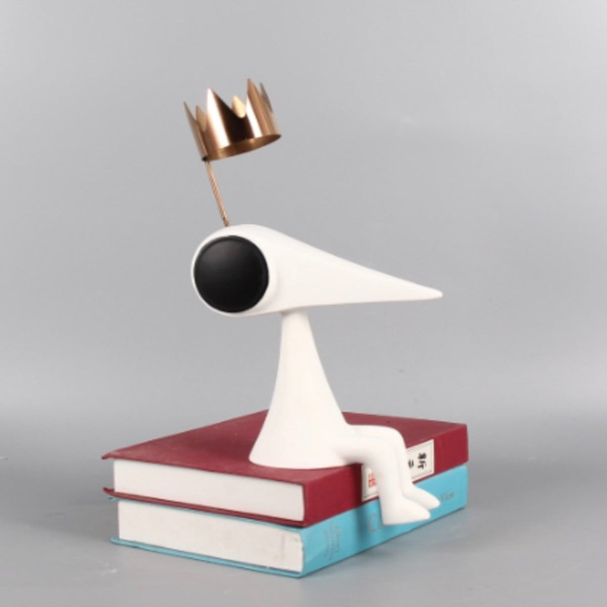 Gold crowned figure on red & teal books