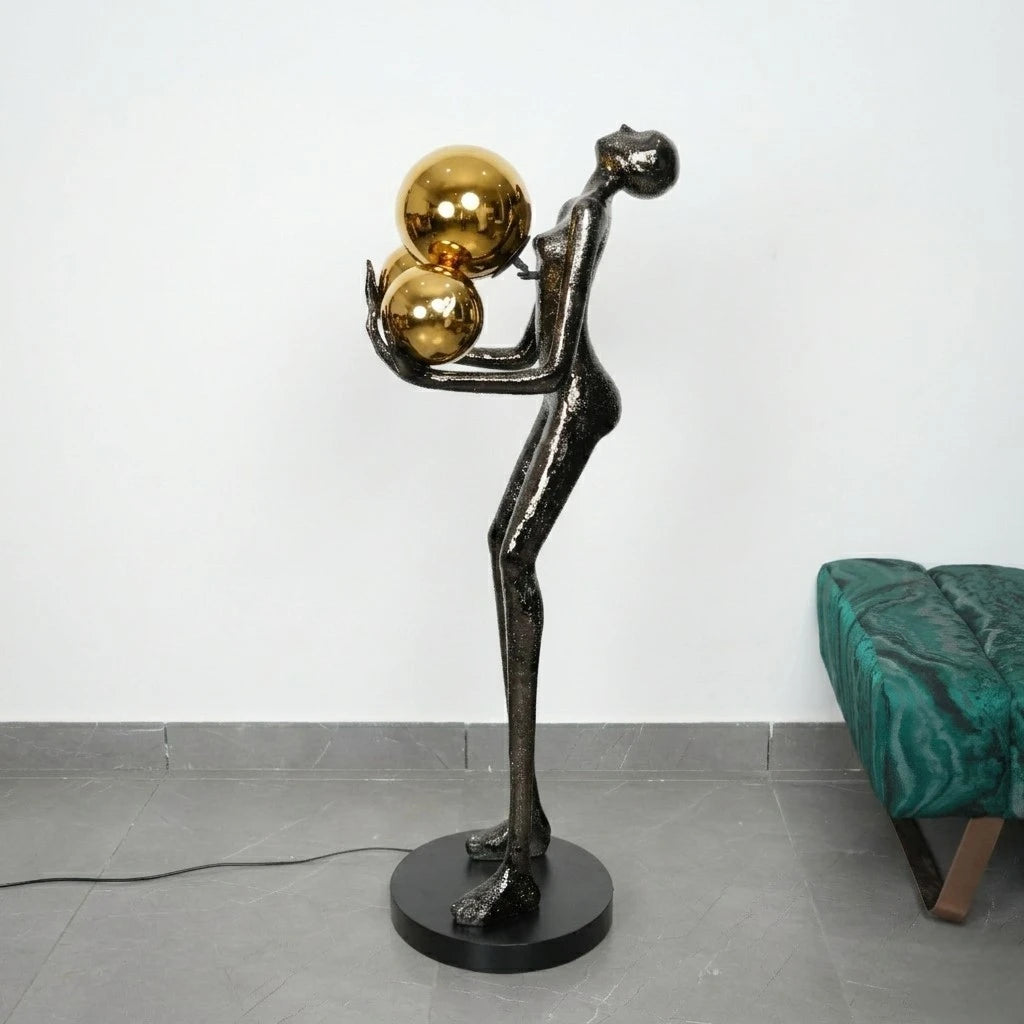 Decorative floor lamp with a black and gold design on a gray floor.