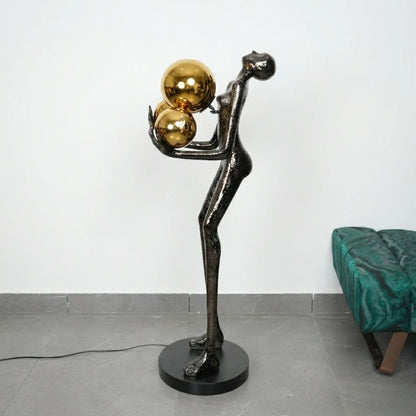 Decorative floor lamp with a black and gold design on a gray floor.