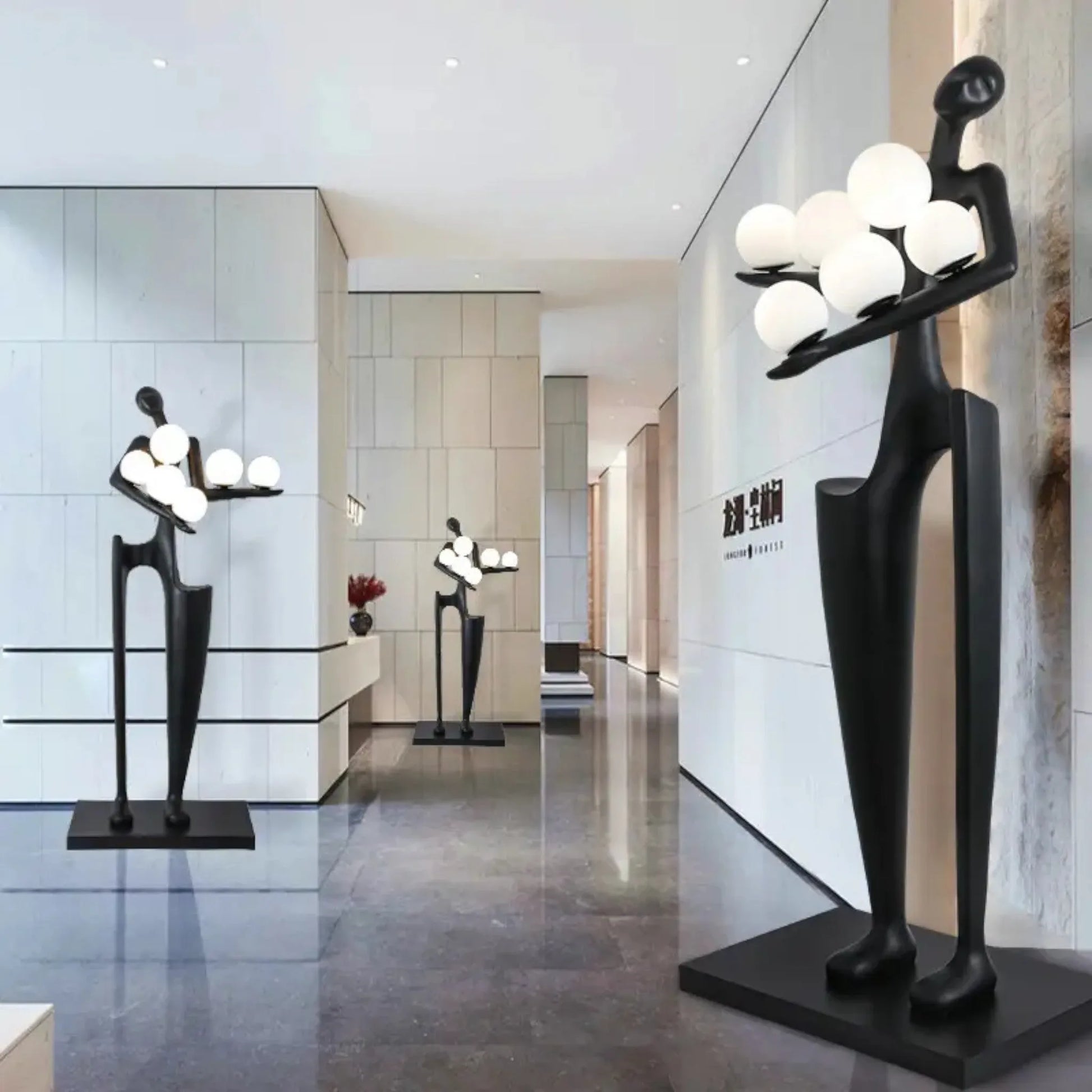 Modern interior with abstract black sculptures and spherical lights.