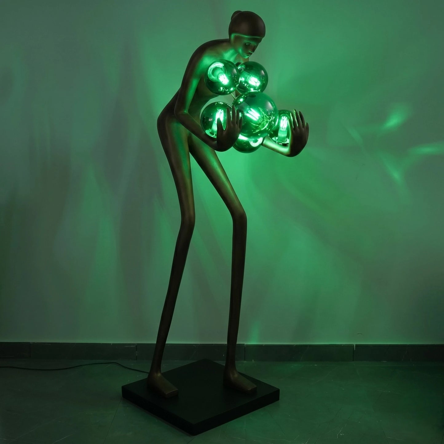 Glow figure lamp, emerald glow on wall, front