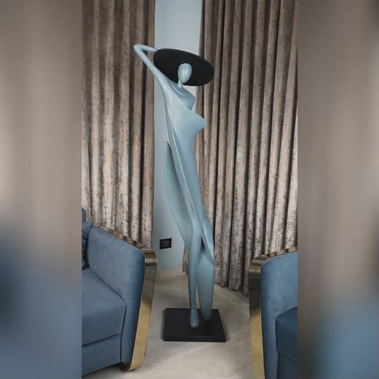 Bluish grey lady sculpture with black hat – tall artistic home décor piece.
