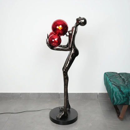 Modern floor lamp with red glass shades and black metal base on a gray floor.
