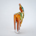 Modern decorative vase with colorful bird design and warm amber glass center