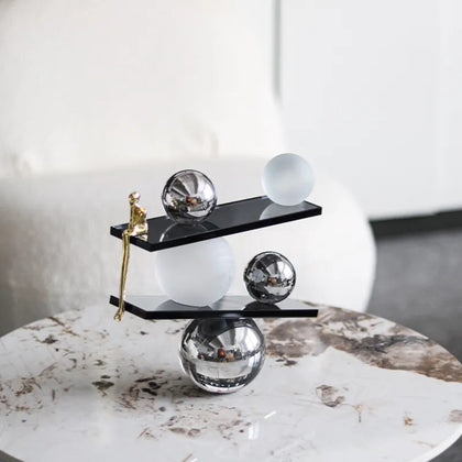 Abstract balancing sculpture with chrome spheres and a small gold figurine